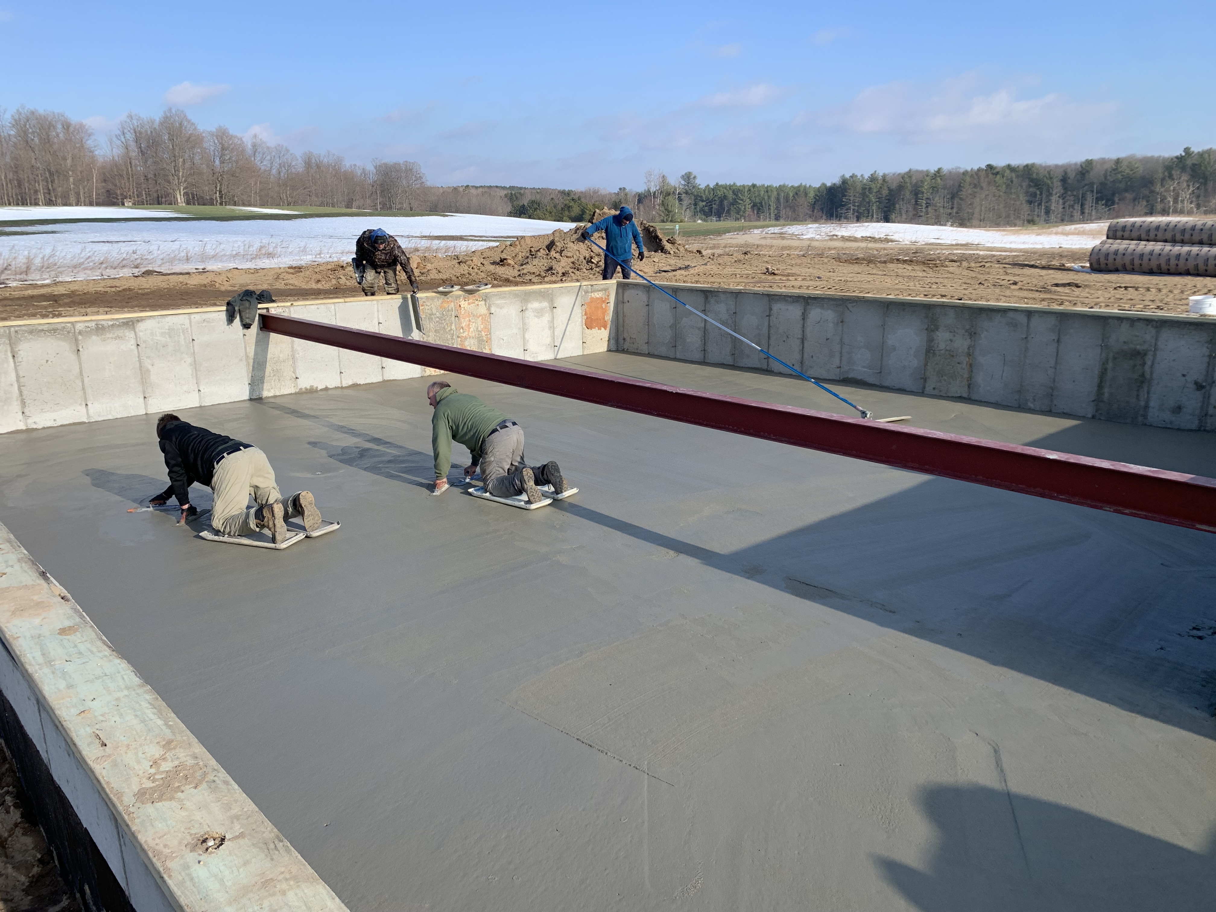 Crew finishing concrete foundation slab — 2025